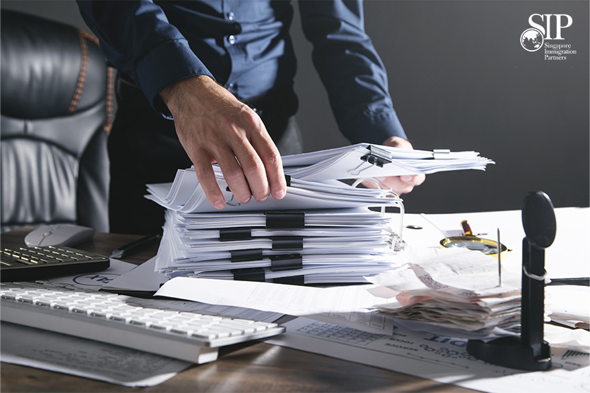 A Person Sorting Through Various Documents on a Table at Home