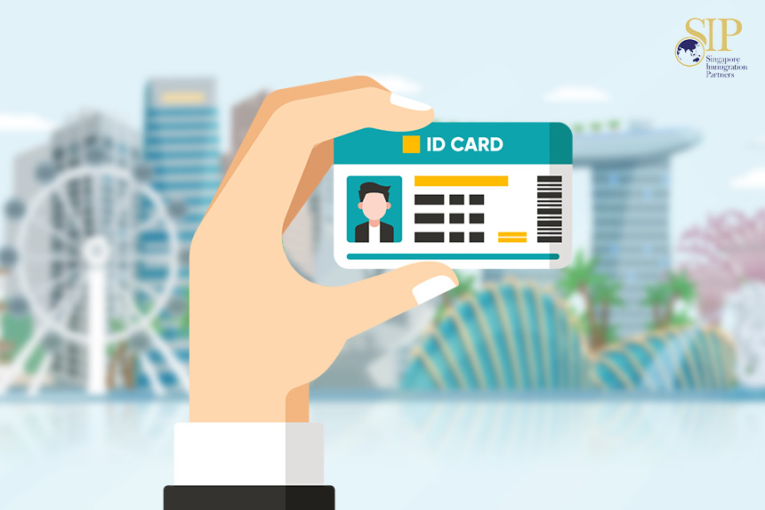 Hand holding an ID card in front of the Singapore skyline.